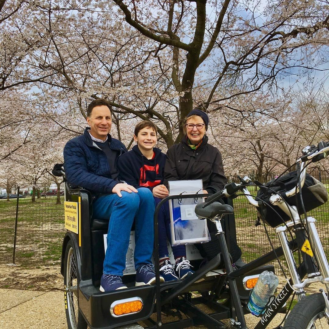 Picture of tricycle with guests with White House in the background